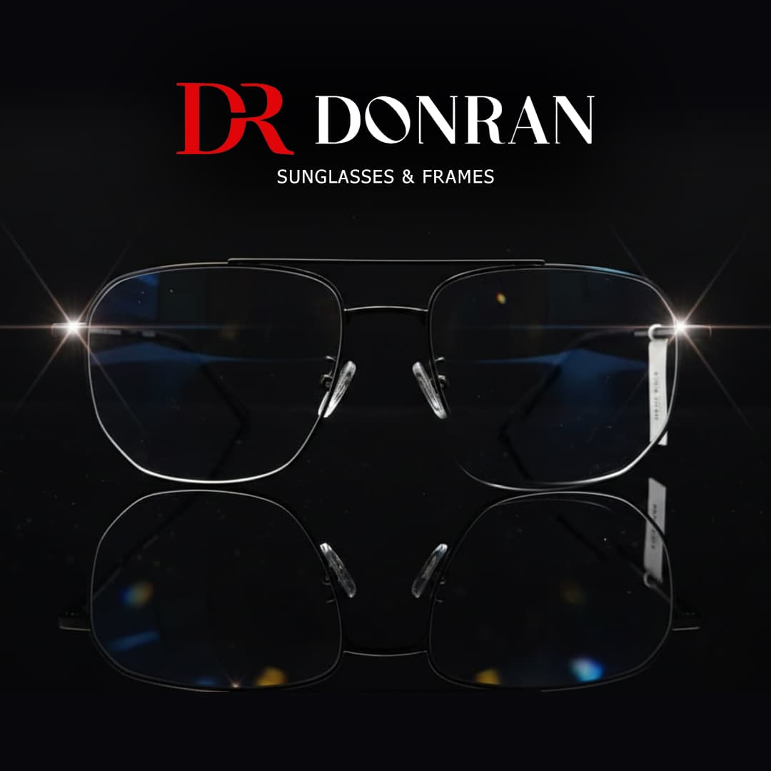 Black metal Donran aviator frames reflecting on a dark surface with bright light glints.